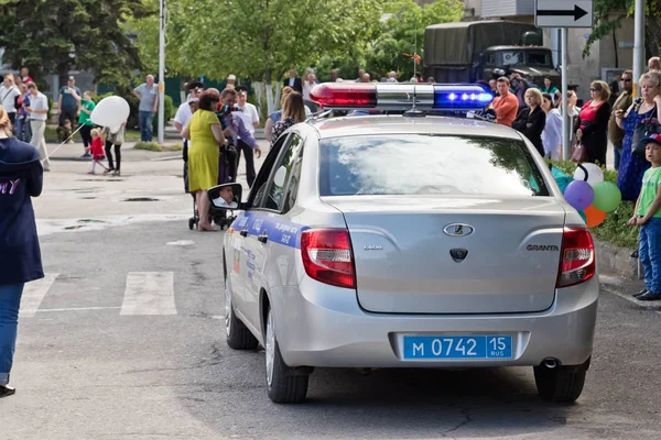 A police car slowly sneaking through the crowd of people celebra — Stock Photo, Image