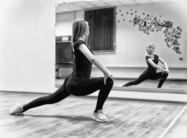 Jovem menina bonita faz exercícios de alongamento na frente do m — Fotografia de Stock