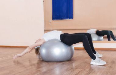 Zarif genç kızın fitness egzersiz egzersiz topu üzerinde yaptığı