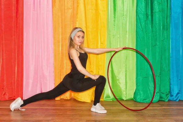 Mujer joven flexible en ropa deportiva hace ejercicios con un aro — Foto de Stock