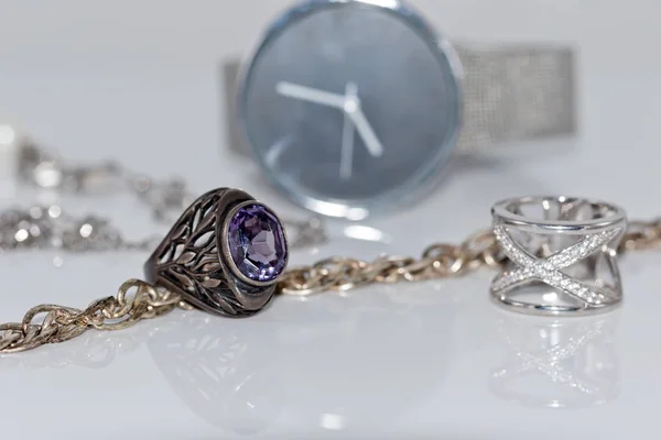 Silver ring and chain on the background of watches — Stock Photo, Image