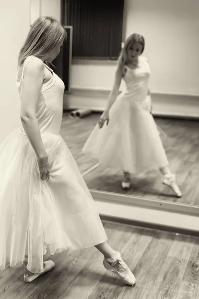 Beautiful young dancer posing in front of a mirror