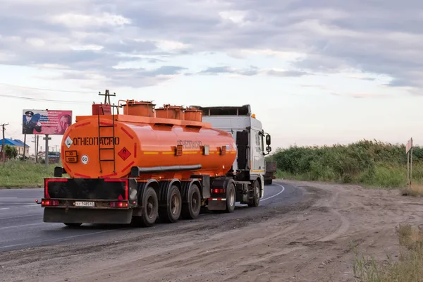 Ένα φορτηγό που τραβούν ένα δεξαμενόπλοιο πορτοκαλί καυσίμου στο δρόμο παράκαμψης — Φωτογραφία Αρχείου