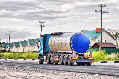 Büyük bir taş döşeli yol üzerinde krom tanker ile kamyon