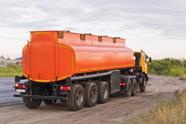 Camion avec camion-citerne orange sur le bord de la route — Photo