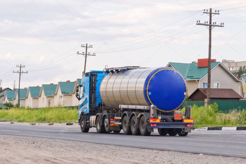 Lorry with chrome tanker on a large paved road 