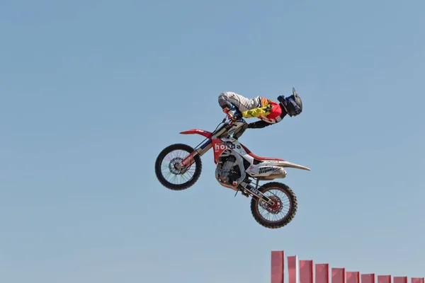 Tricks on a motorcycle jump performed by the athletes during the — Stock Photo, Image