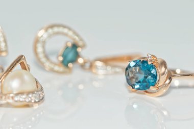 Altın yüzük ve küpeler ile değerli taşlar kakmalarla süslemeli servis tabakları