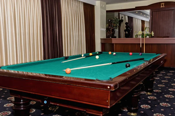 Tavolo da biliardo indossato con stecca e palle nella grande sala del gu — Foto Stock
