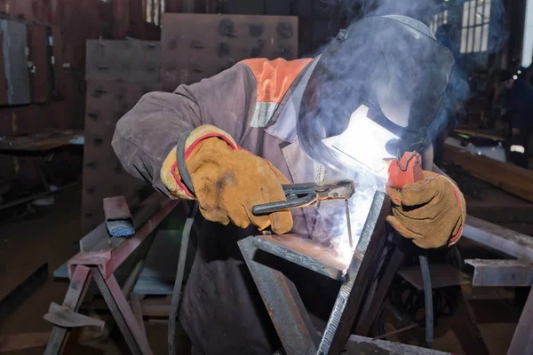 Soldador en condiciones de taller soldadura de muestra de chapa metálica a un —  Fotos de Stock