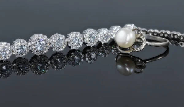 Bracelet en argent avec de nombreux diamants étincelants et une bague avec un j — Photo