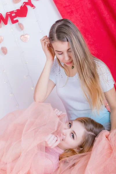 Dos lindas novias de pelo largo en vestidos se sientan y abrazan de nuevo —  Fotos de Stock