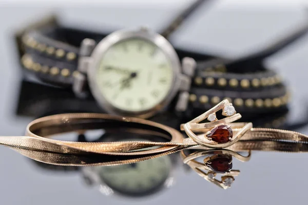 Elegante anillo de oro y cadena se encuentran en el fondo de la mujer wat — Foto de Stock