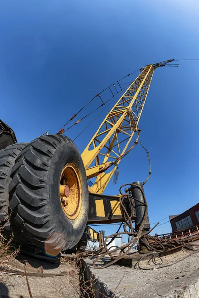 Wheeled yellow truck crane for loading heavy metal