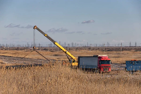 Loading of large-diameter steel pipes in the steppe using a truc — Stock Photo, Image