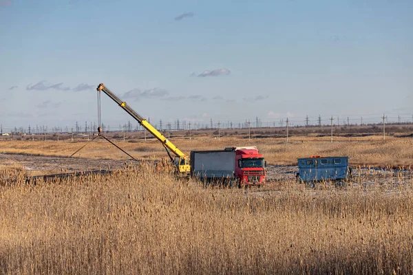 Loading of large-diameter steel pipes in the steppe using a truc — Stock Photo, Image