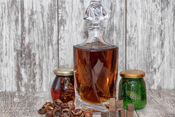 A curved crystal decanter with homemade moonshine stands on a wo — Stock Photo, Image