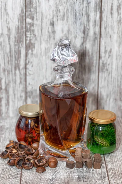 A curved crystal decanter with homemade moonshine stands on a wo — Stock Photo, Image