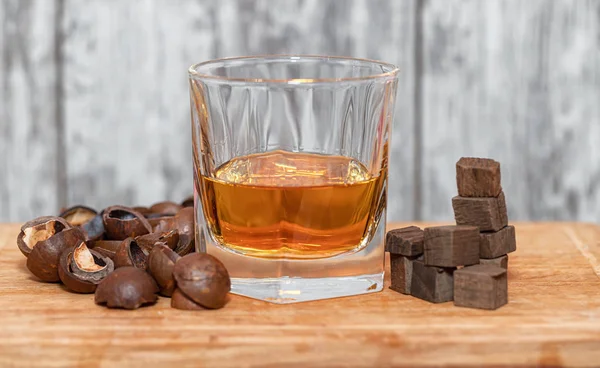 Glass of poured homemade whiskey with ingredients for cookin — Stock Photo, Image