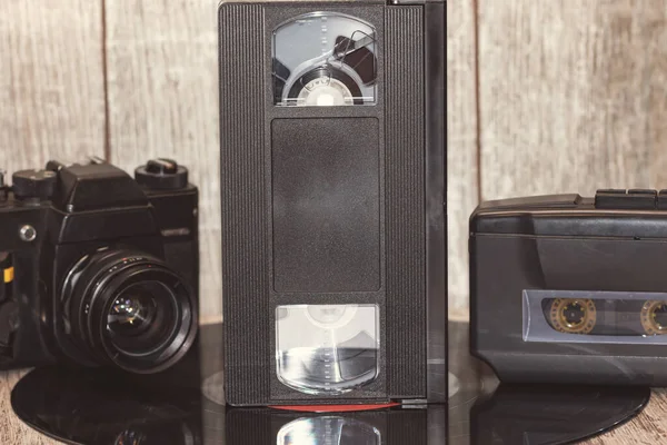 90年代の技法 木製の背景にオーディオカセットプレーヤー フィルムカメラ Vhsカセット — ストック写真