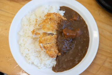 Beyaz tabak üzerine körili domuz pilavı.