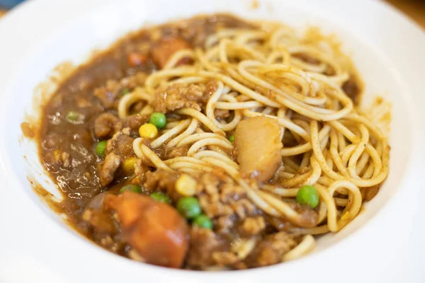 Spaghetti al curry in un piatto bianco . — Foto Stock