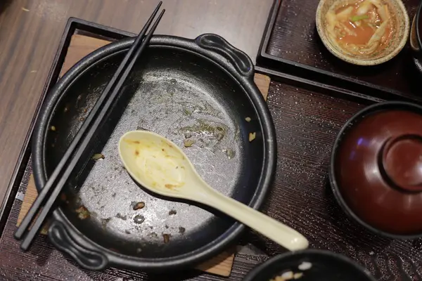 一个肮脏的黑盘，勺子和筷子. — 图库照片
