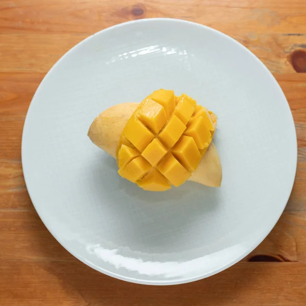 Mango amarillo sobre fondo de madera blanca plato . —  Fotos de Stock