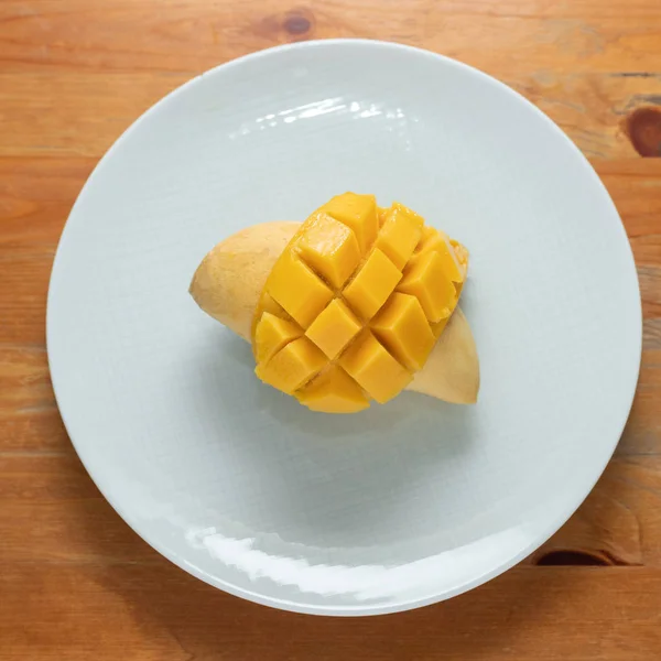 Beyaz ahşap arka planda mango sarısı.