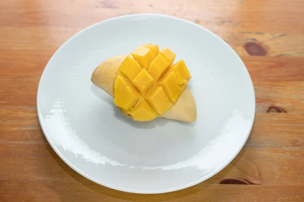 Mango amarillo sobre fondo de madera blanca plato . — Foto de Stock