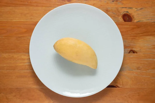 Mango žlutá na misce bílé dřevo pozadí. — Stock fotografie
