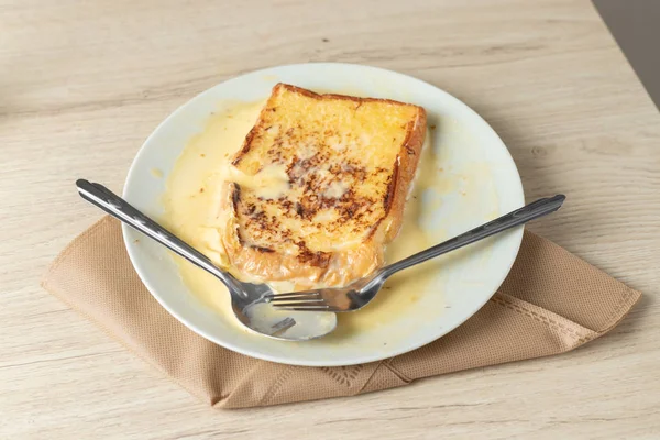Toast auf einem weißen Teller auf einem Holztisch. — Stockfoto