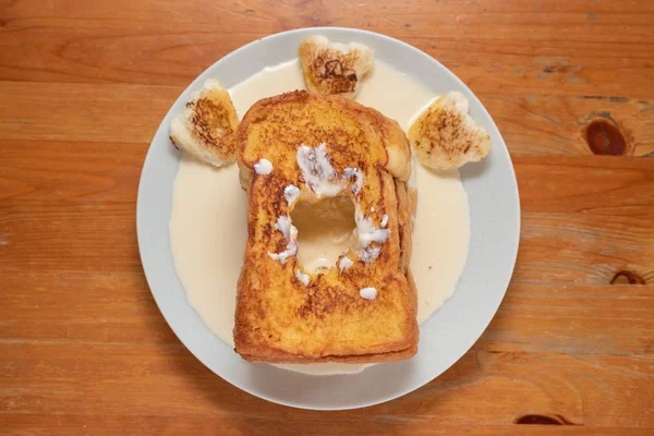 Toast na białym talerzu na drewnianym stole. — Zdjęcie stockowe