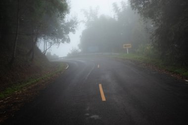 Dağdaki sisli yolda arabasıyla 