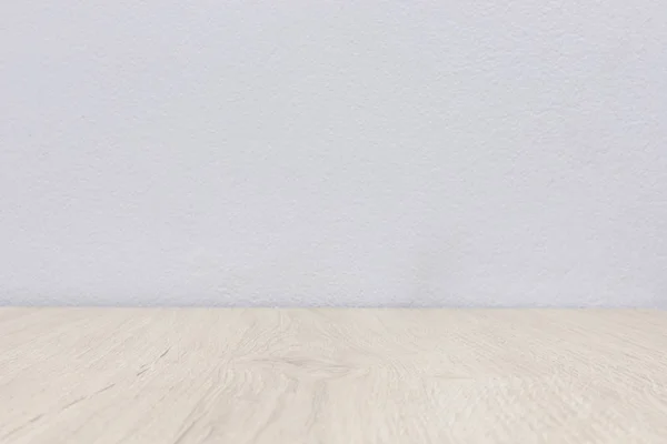 Boş ahşap masa ve beyaz beton duvar.