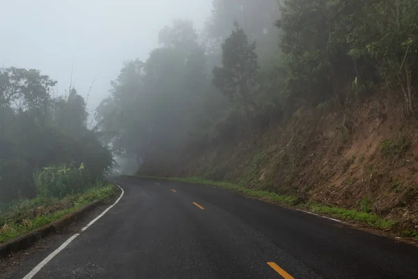 Nebbioso asfalto rurale prospettiva autostrada con linea bianca, nebbia r — Foto Stock