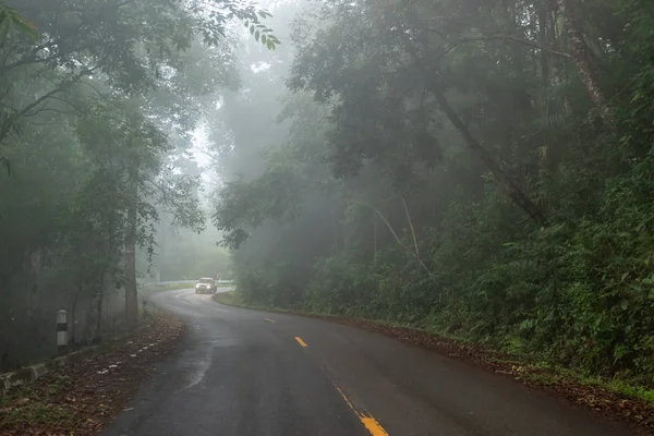 Noggy carretera en la montaña con un coche en el fondo . —  Fotos de Stock