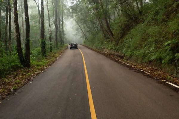 Strada appannata sulla montagna con un'auto sullo sfondo . — Foto Stock