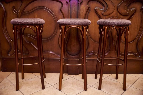 High wooden bar stools stand near the bar counter