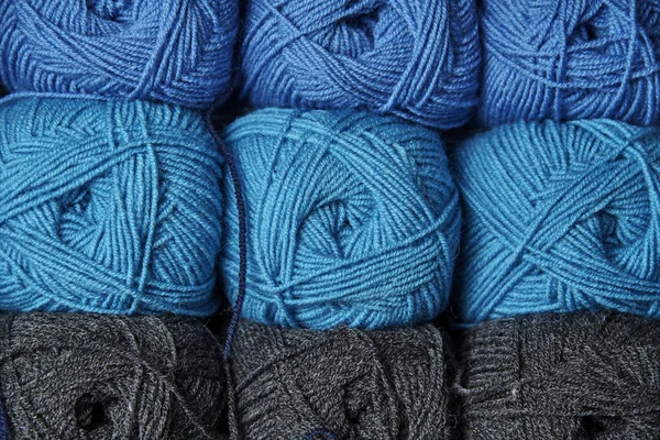 Rows of blue and gray tangles of yarn close-up.