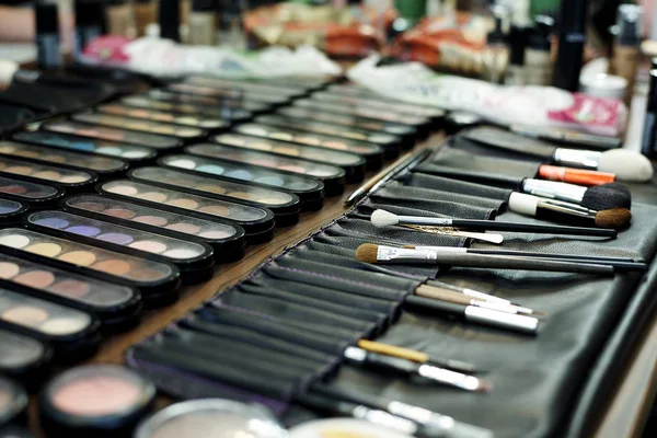 A set of different shadows and makeup brushes close-up.