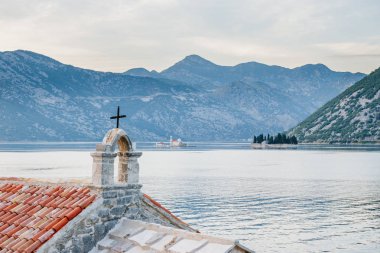 Adriyatik, Akdeniz mimarisi. Eski kilisenin ön planda çapraz. Pitoresk bay. Saint George Adası manastır, kilise Our Lady kayalar, Karadağ, Kotor Körfezi.