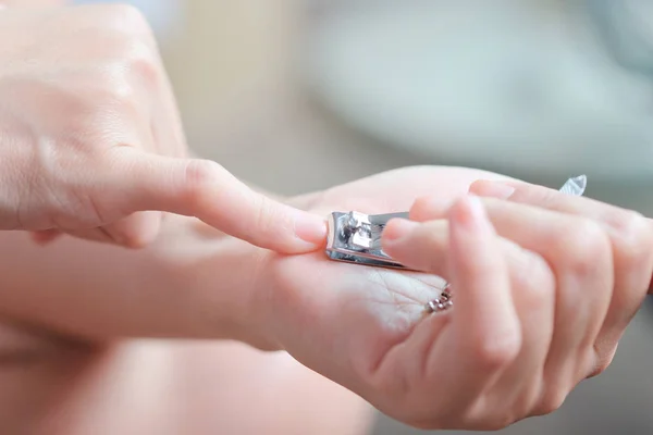 Женщина стрижет ногти — стоковое фото