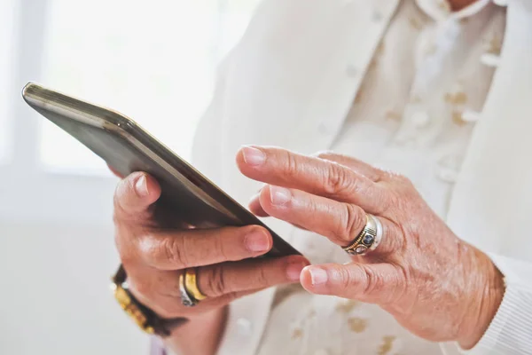 Starší žena pomocí svého mobilního telefonu — Stock fotografie