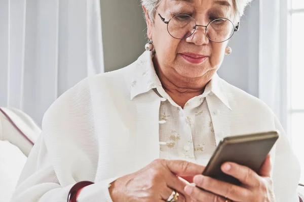 Starší žena pomocí svého mobilního telefonu — Stock fotografie