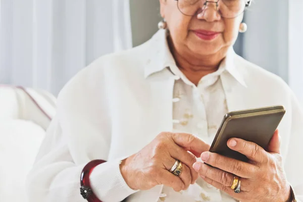 Mujer mayor usando su teléfono móvil — Foto de Stock