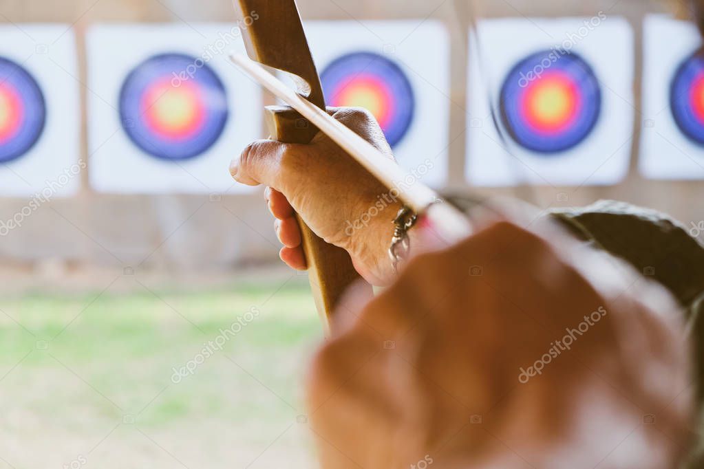 Archer holds his bow aiming at a target