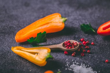 Sarı ve turuncu peppe ile masada kaşık içinde farklı baharatlar
