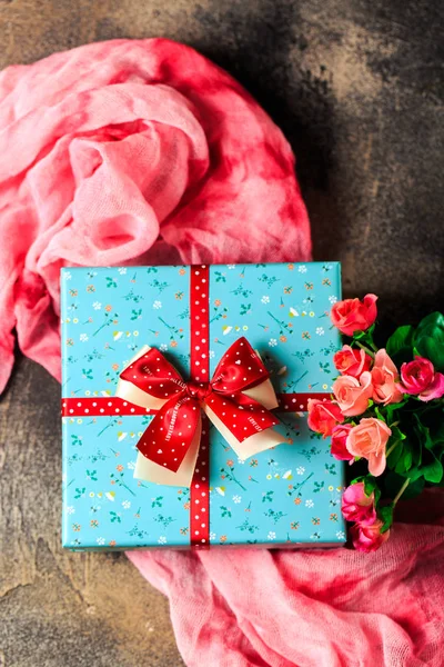 Scatola regalo blu con fiori e nastro rosso con fiori di rosa su b — Foto Stock