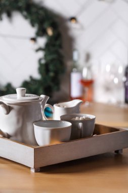 Yeni yıl masasında bir fincan sıcak çikolata, şeker kasesi ve çaydanlık. Noel süslemesi